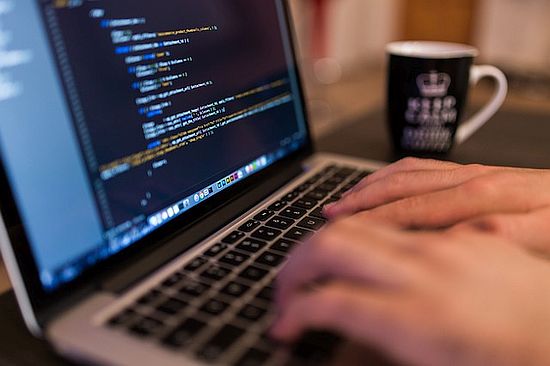 laptop with code being typed