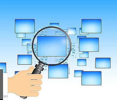 Magnifying glass over computer monitors