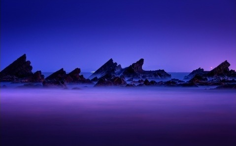 Rocks rising out of purple sea mist